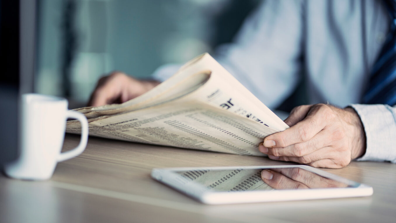 Reading the newspaper at table